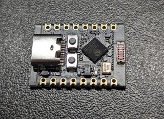 ESP32-C3 Super Mini board: a small black PCB with a USB-C socket, the ESP32-C3 chip and two rows of castellated pin pads