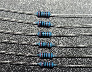 Several 4.7 kilohm metal film resistors with colour bands and long leads