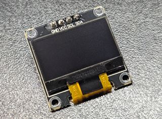 SSD1306 OLED display module with four pins labelled GND, VCC, SCL and SDA